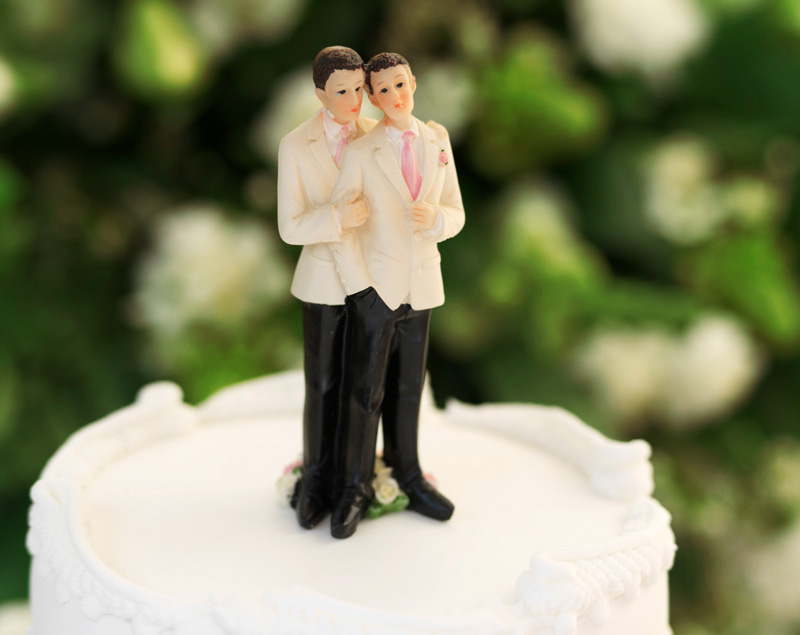 two men on top of a wedding cake