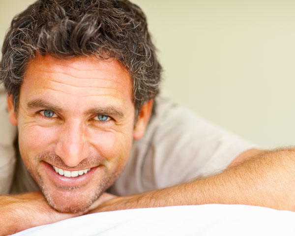 a man smiles in bed