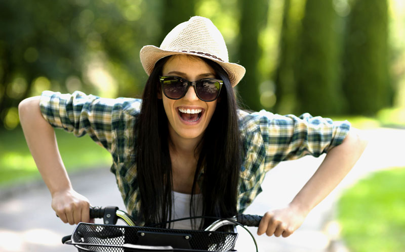 Girl wears 'ironic' hat riding a bike