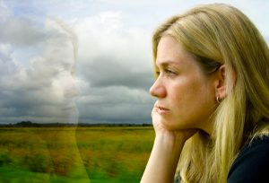 Woman looks out window loney