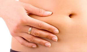 Woman squeezes her bloated belly