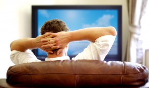 Man sits on couch watching tv